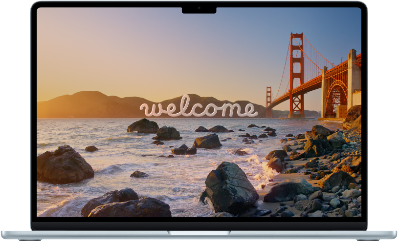 An open MacBook Air with “Welcome” on the screen.