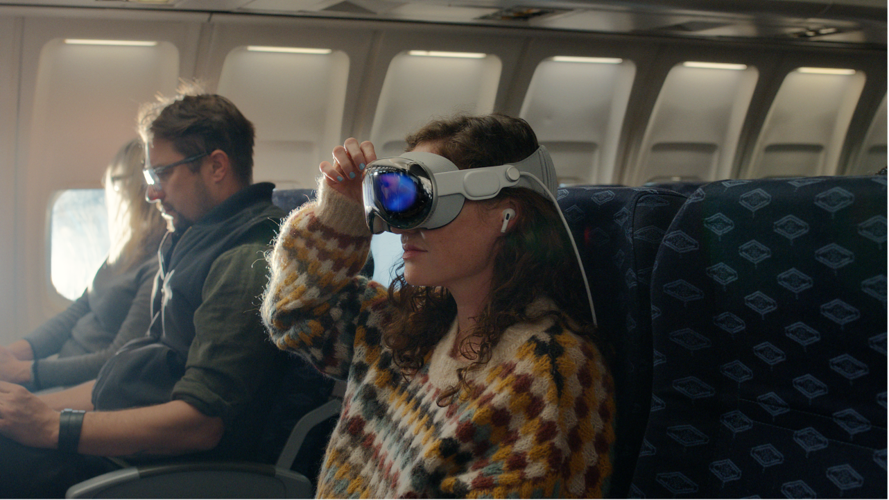 Eine Person, die die Apple&nbsp;Vision&nbsp;Pro aufgesetzt hat und in den Ohren AirPods Pro trägt.
