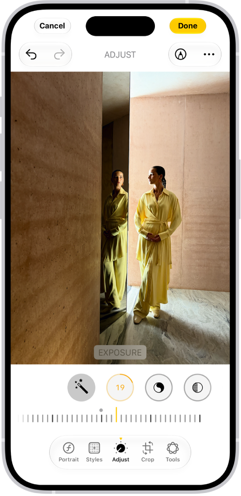 On iPhone, a phot is being edited in the Photos app. The Adjust button is selected, and a slider is available below the Exposure setting to adjust its level. The Cancel button is in the top-left corner of the screen and the Done button is in the top-right corner.