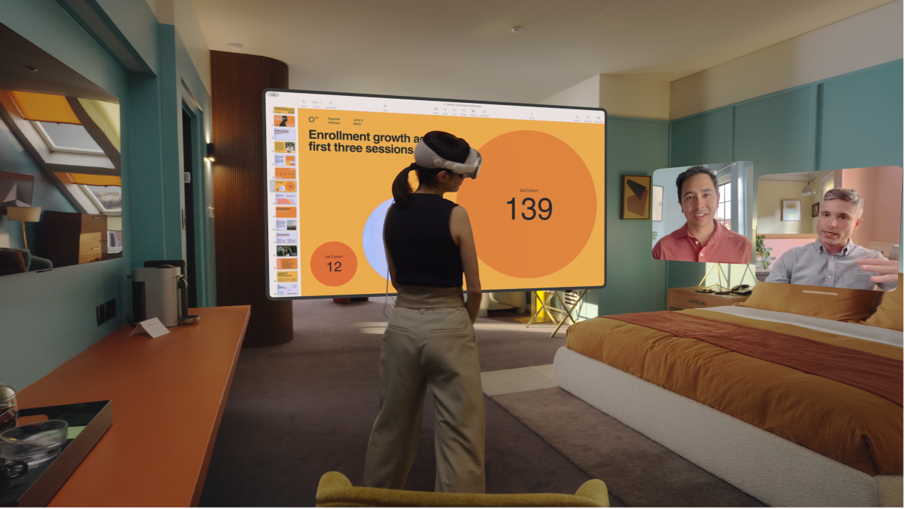 A person wearing Apple&nbsp;Vision&nbsp;Pro and having a FaceTime call. The tiles for others on the call are visible next to a shared screen.