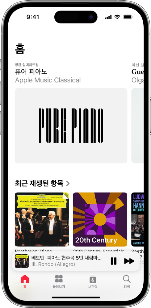iPhone이 Apple Music Classical의 홈 탭을 표시함. 화면 상단에 추천 플레이리스트가 있음. 화면 중앙에 최근 재생한 음악 플레이리스트가 있고, 그 아래에는 현재 재생 중인 트랙을 표시하는 미니 플레이어가 있음. 화면 최하단에는 홈, 둘러보기, 보관함 및 검색 버튼이 있음.