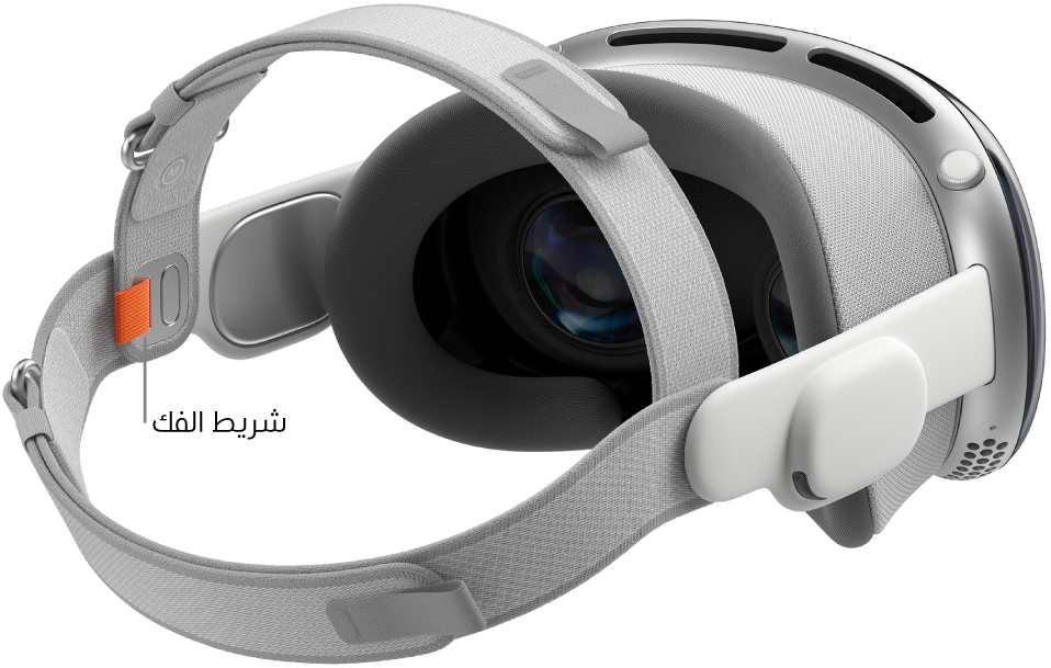 Apple&nbsp;Vision&nbsp;Pro ملحق بها الحزام بشريطين. يظهر لسان تحرير برتقالي على الجانب الداخلي من الحزام بشريطين.