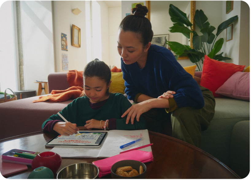 Una bambina che disegna su un iPad con Apple&nbsp;Pencil mentre la madre osserva da vicino.