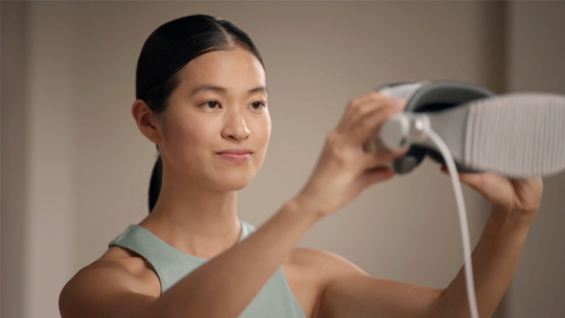 A person holding Apple&nbsp;Vision&nbsp;Pro in front of them at eye level to capture their Persona.