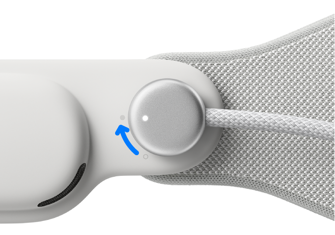 El Apple&nbsp;Vision&nbsp;Pro con el cable de energía conectado a la correa de audio izquierda. El cable se gira en sentido de las agujas del reloj para fijarlo en su lugar.