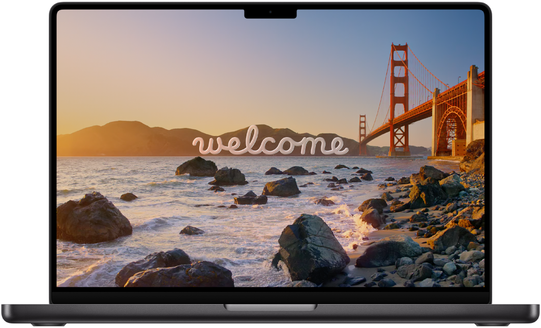 A MacBook Pro with the lid open. The display shows the word “Welcome.”