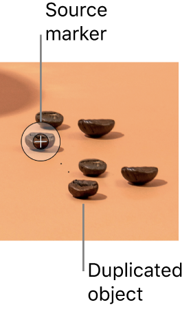 A photo of coffee beans, including an extra bean that has been duplicated using the Clone tool.