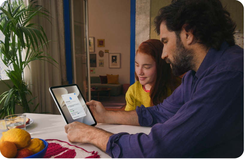 A child and parent looking at an iPad together.
