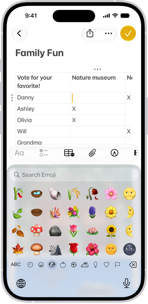 Une note est ouverte dans l’app Notes dans la moitié supérieure de l’écran et le clavier des Emoji est ouvert dans la moitié inférieure.